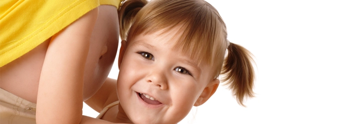 Close-up of a child in a yellow shirt with pigtails, set against a clean white background.